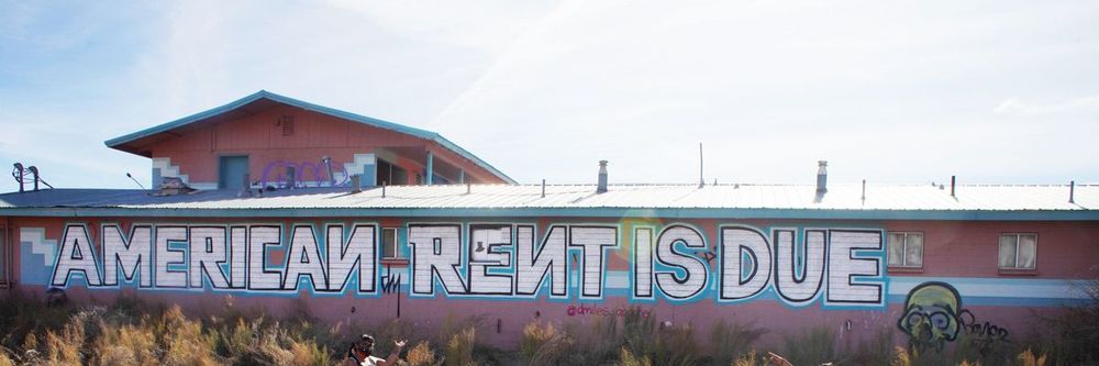 Graffiti on building: American rent is due